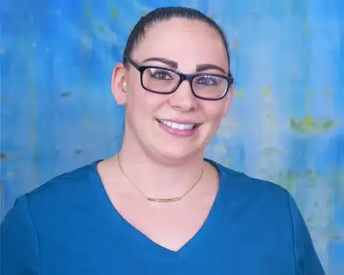 Staff member wearing glasses smiling at Lake Ridge dental practice.