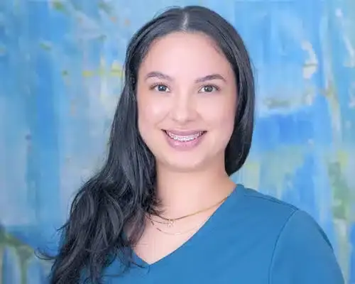 Smiling female dental staff member wearing blue scrubs at Lake Ridge dental practice.