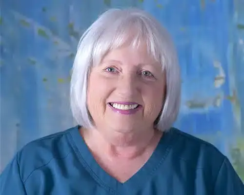 Female dental staff member with white hair smiling at Lake Ridge, VA practice.