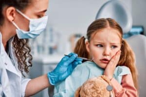 Young girl with concerned expression during dental examination by dentist in Lake Ridge.